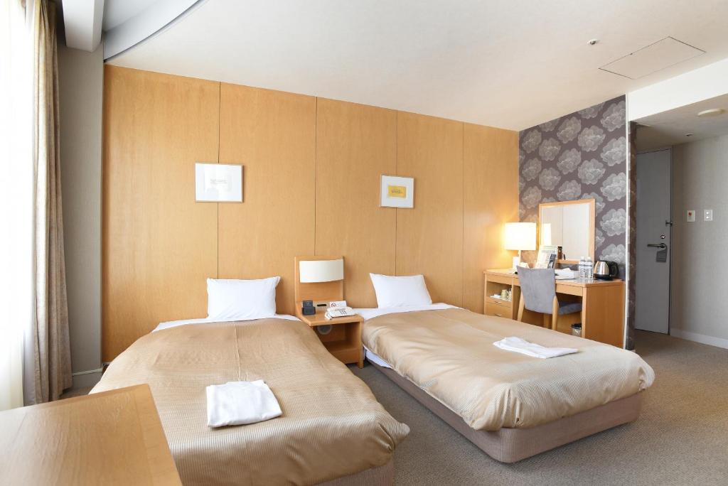 Un pat sau paturi într-o cameră la Hotel Grand Vert Gizan
