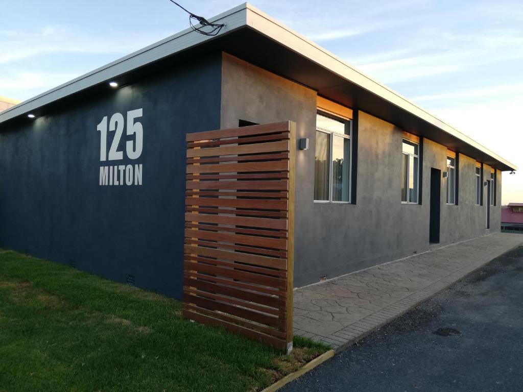 ein Gebäude mit einer großen Holztür an der Seite in der Unterkunft 125 Milton in Milton