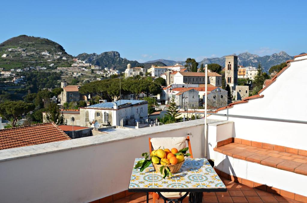 a table with a bowl of fruit on a balcony at Casa Cecilia in Ravello