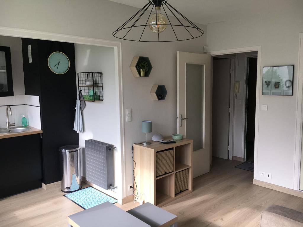 a living room with a table and a chandelier at Cosylocation La Varende 71 in Rennes