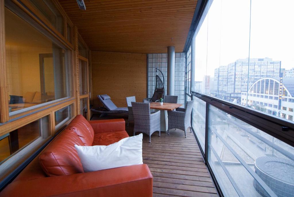 a balcony with a couch and a table on a building at 2ndhomes Luxury Kamppi Center Apartment with Sauna in Helsinki
