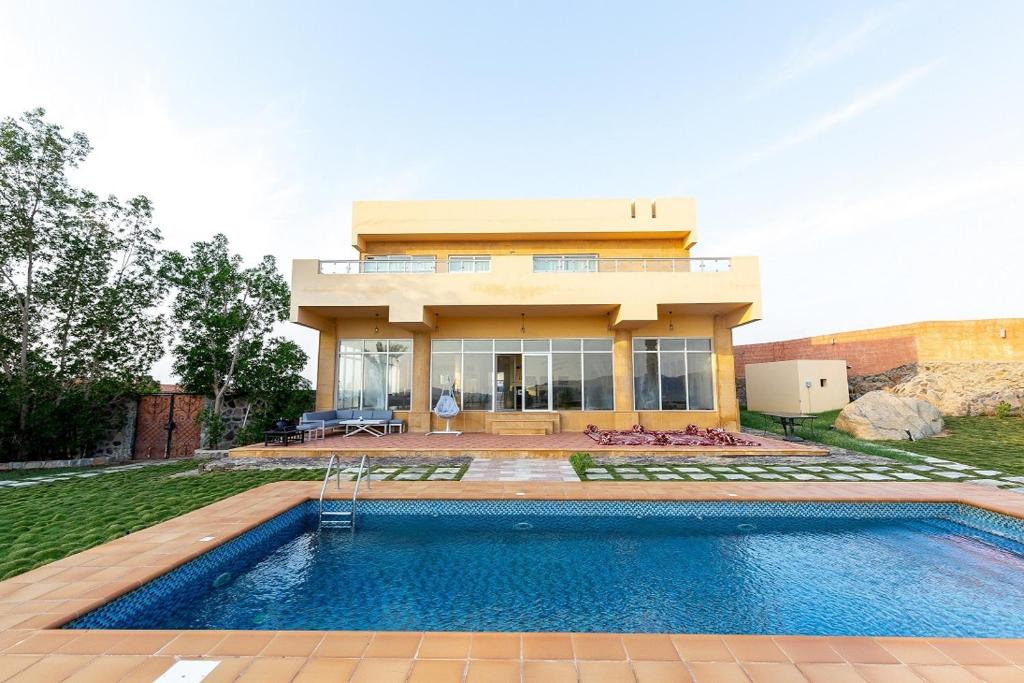 a house with a swimming pool in front of a house at Tal Al-Jude Villa in Jeddah