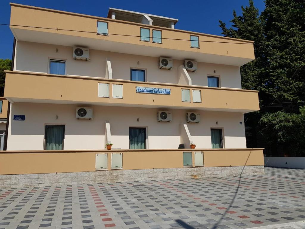 a large building with windows and a roof at Apartmani Dobra Villa in Vodice