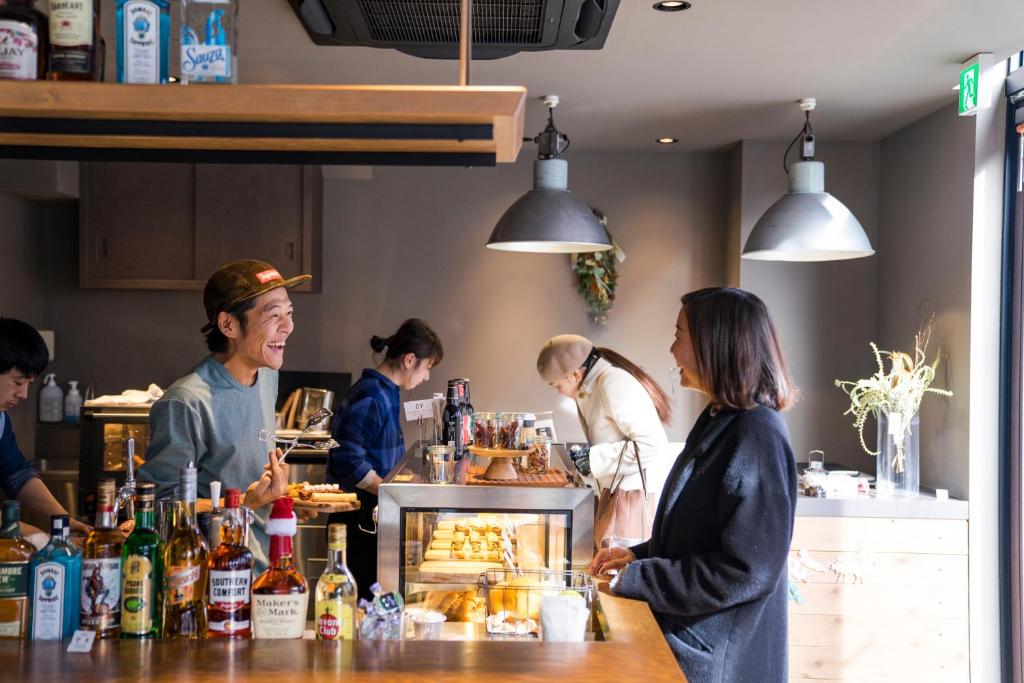 eine Gruppe von Menschen, die in einer Küche Essen zubereiten in der Unterkunft Busoan Library & Hostel in Machida