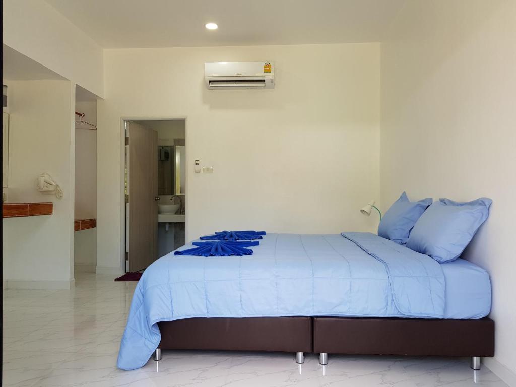 a bedroom with a bed with blue pillows at Mook Ing Lay in Ko Mook