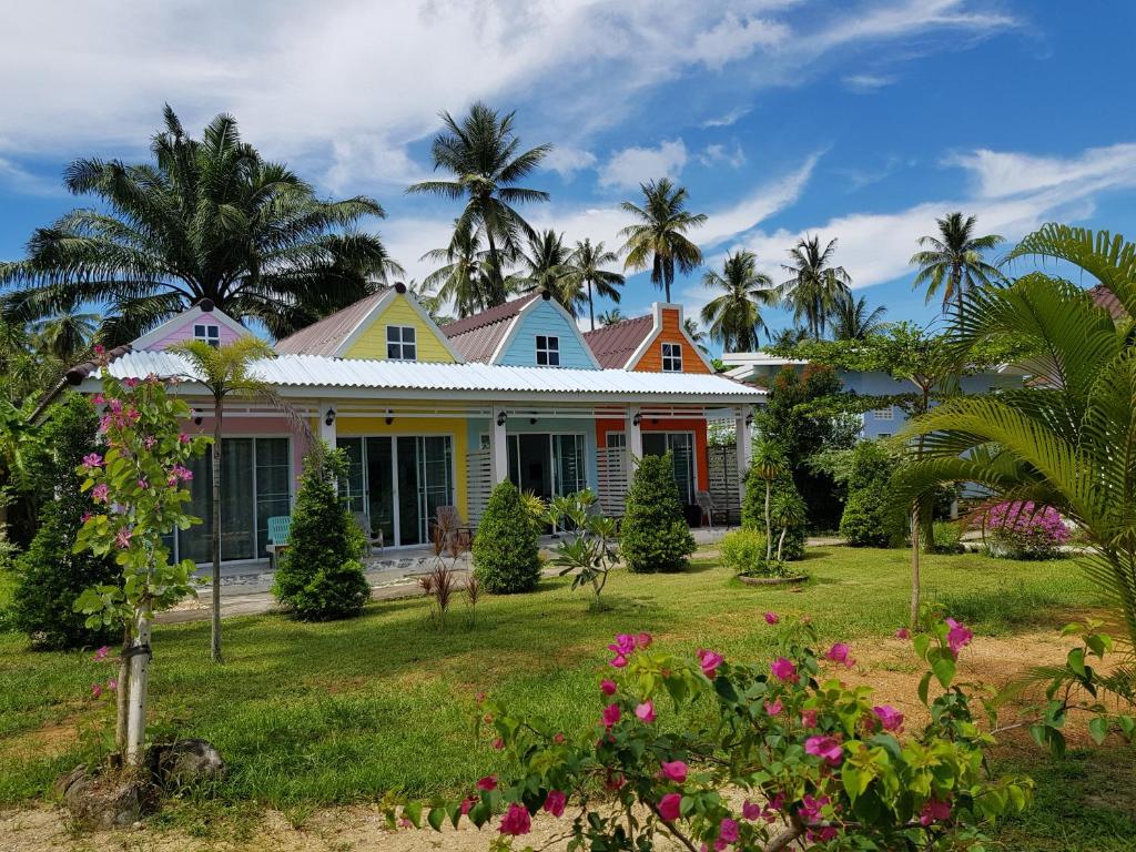a house with palm trees and flowers in the yard at Mook Ing Lay in Ko Mook