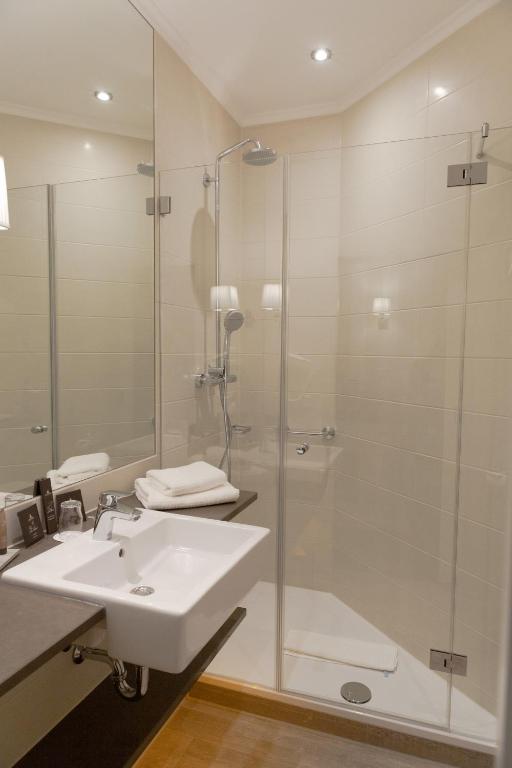 a bathroom with a sink and a glass shower at Europa Hotel Kühlungsborn in Kühlungsborn