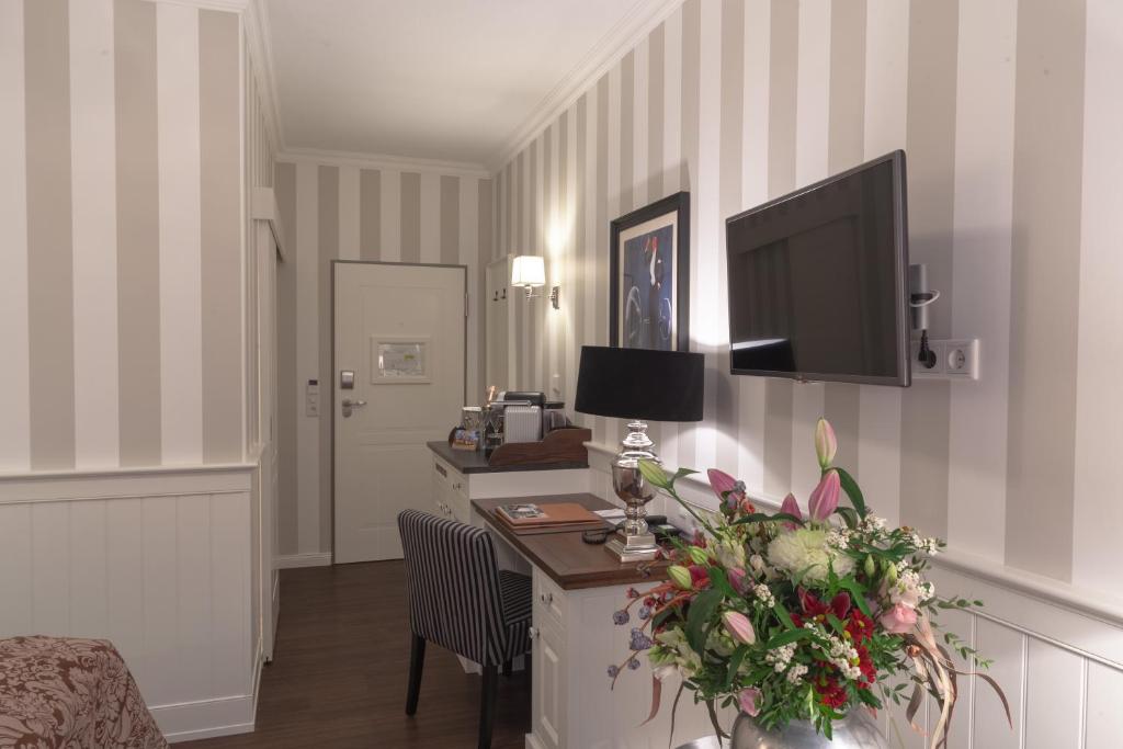 a hotel room with a desk with a tv on the wall at Europa Hotel Kühlungsborn in Kühlungsborn
