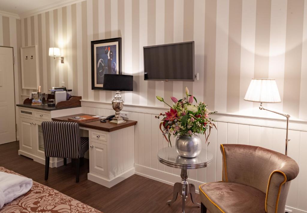 a hotel room with a desk and a bed and a room at Europa Hotel Kühlungsborn in Kühlungsborn