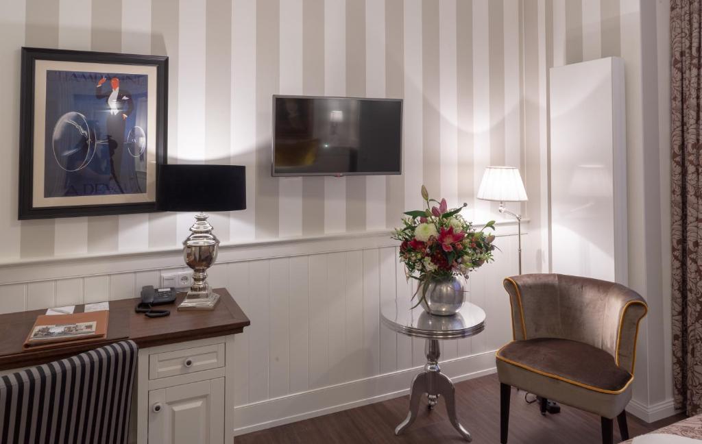 a hotel room with a desk and a chair and a tv at Europa Hotel Kühlungsborn in Kühlungsborn