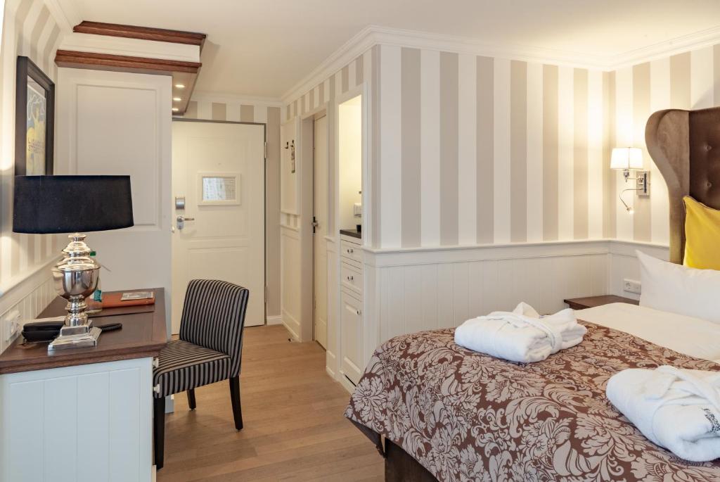 a hotel room with a bed and a desk and a chair at Europa Hotel Kühlungsborn in Kühlungsborn