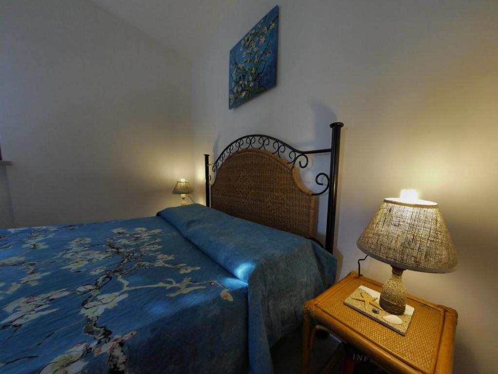 a bedroom with a bed and a lamp on a table at Conero Guest House in Numana