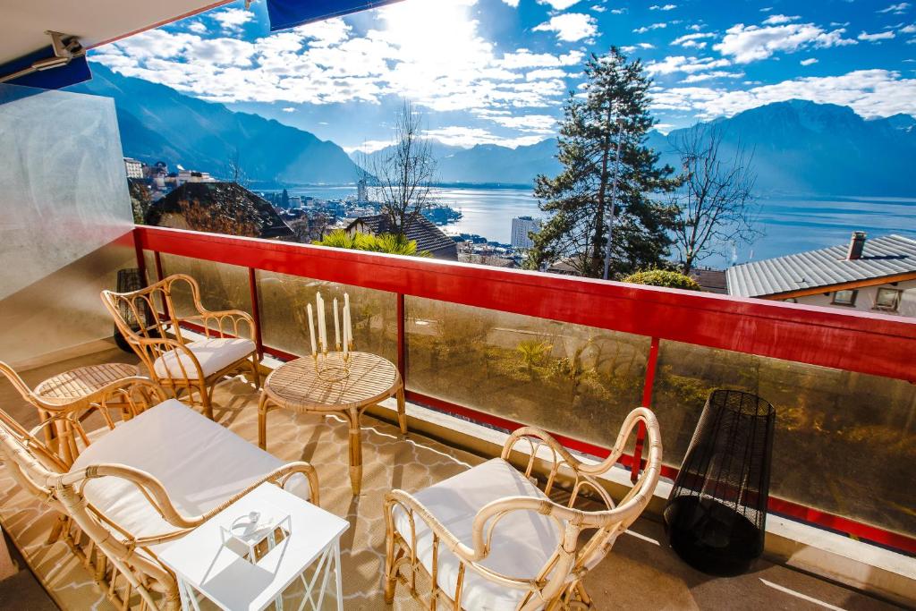 a balcony with chairs and tables and a view of the mountains at Terrace with Lake & Mountain View in Montreux