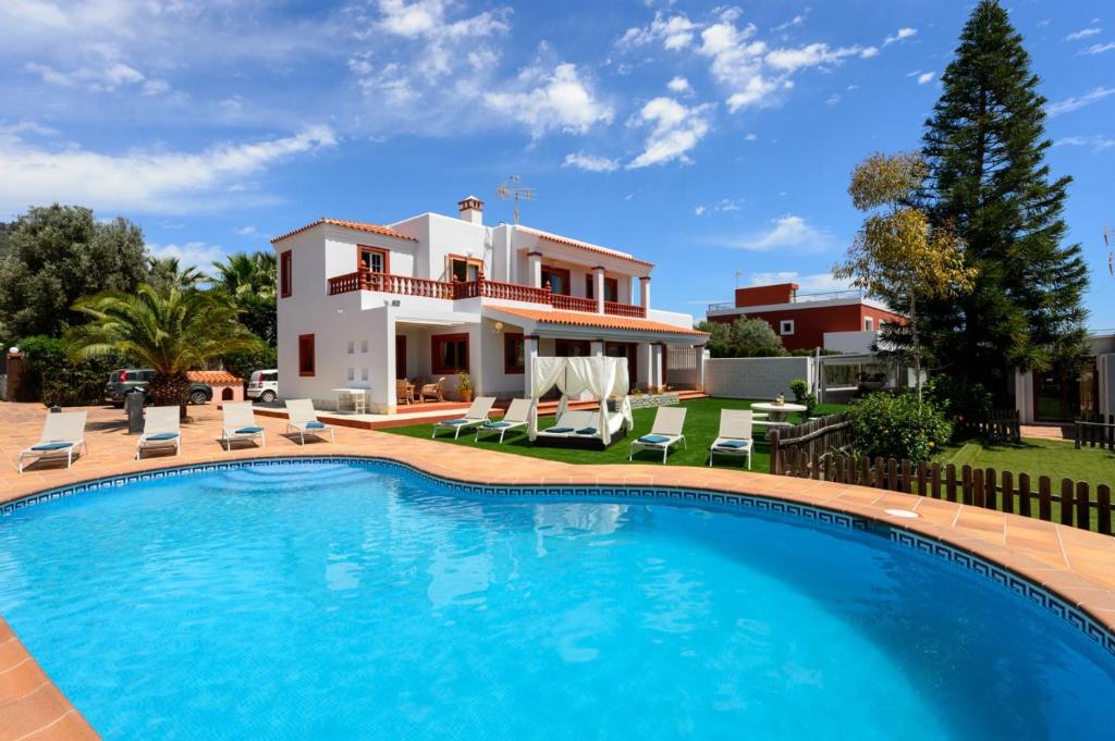 a villa with a swimming pool in front of a house at Sa Carroca Villa in Sant Josep de sa Talaia