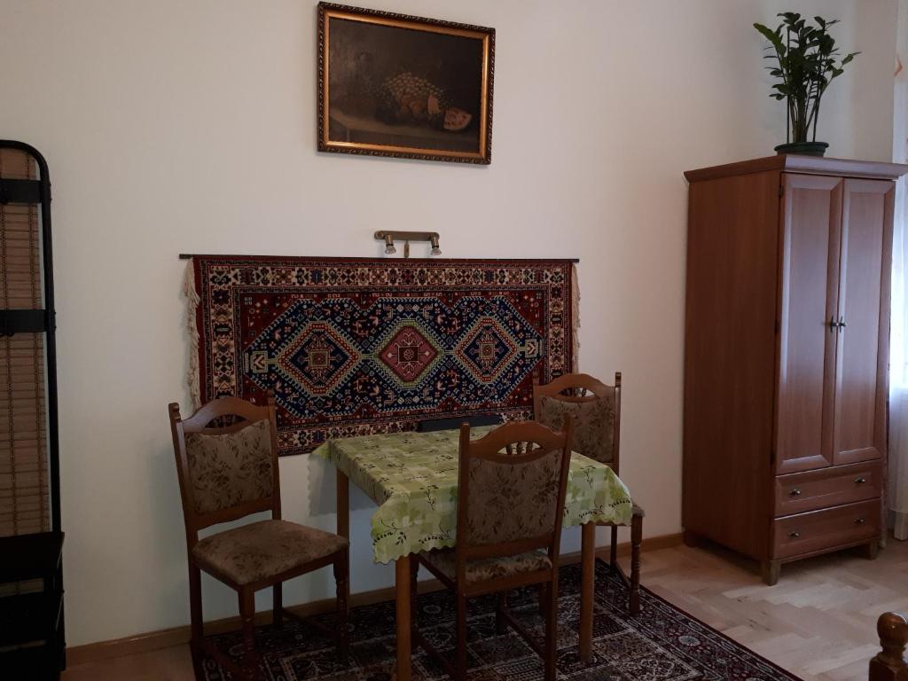 a dining room with a table and chairs and a rug at Apartment in the "antique street" in Budapest