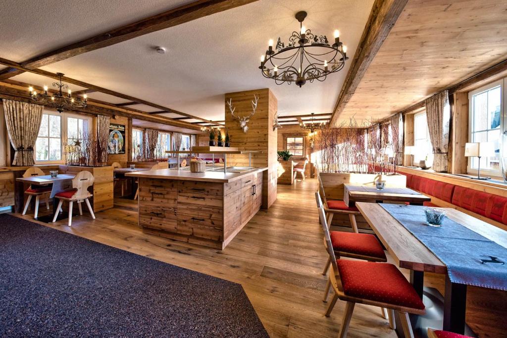 a dining room with wooden floors and a chandelier at Hotel Sonneneck Titisee -Adults Only- in Titisee-Neustadt