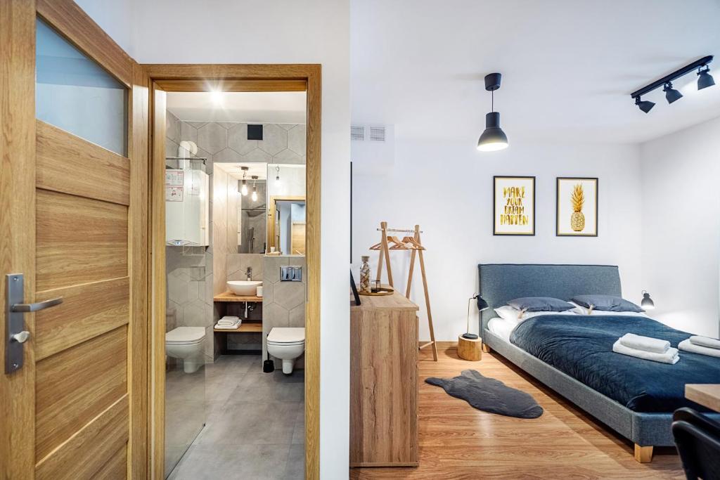 een slaapkamer met een bed en een badkamer bij Gold Apartments Your Holiday Home in Krynica Zdrój
