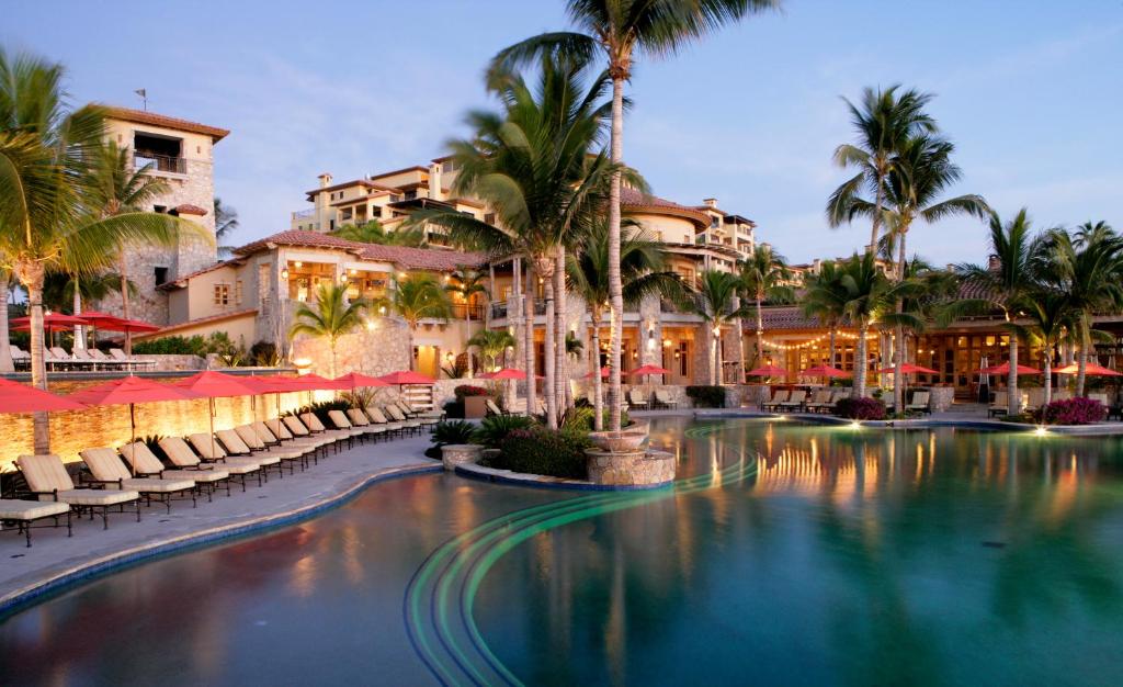 卡波聖盧卡斯的住宿－莊園海灘俱樂部及公寓，一个带椅子和棕榈树的度假村游泳池