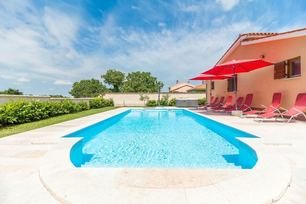 basen z czerwonym parasolem i krzesłami oraz dom w obiekcie Villa Tramonto 4 stars, Krnica w mieście Krnica