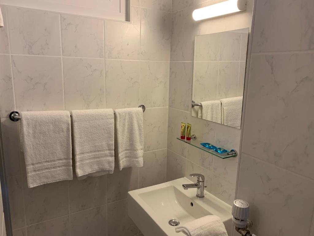 a bathroom with a sink and a mirror and towels at Eh!Toi Self Motel in Etoy