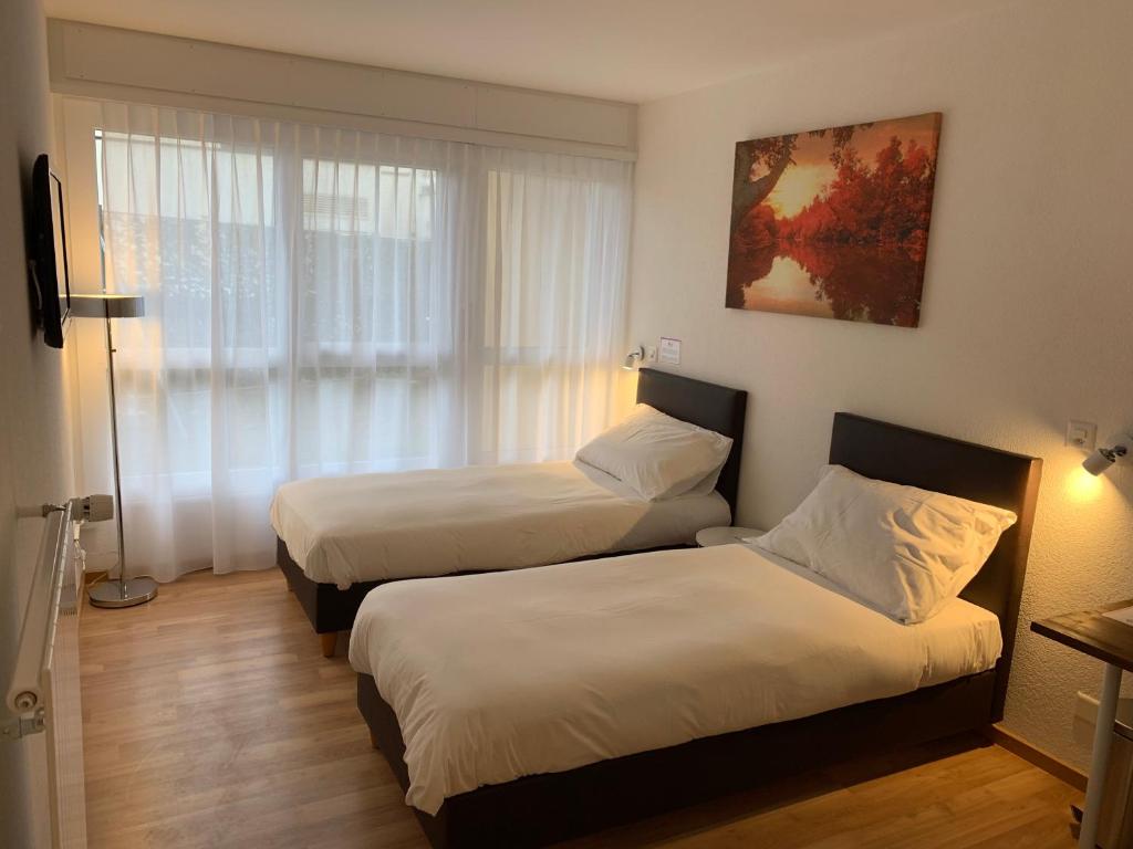 a hotel room with two beds and a window at Eh!Toi Self Motel in Etoy