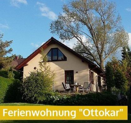 ein weißes Haus mit einem Tisch und Stühlen davor in der Unterkunft Ferienwohnung Ottokar Familie Dust Nähe Neubrandenburg in Knorrendorf