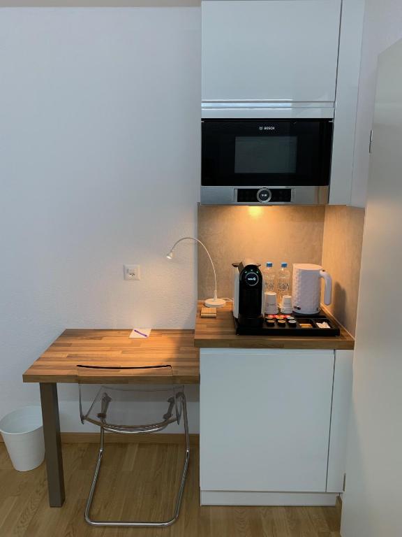a small kitchen with a wooden table and a counter at Eh!Toi Self Motel in Etoy
