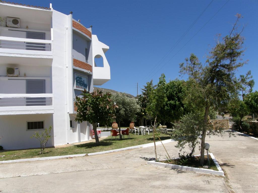a white building with trees in front of it at Megim Hotel in Palaiochora