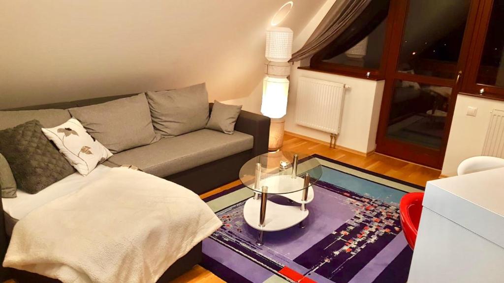 sala de estar con sofá y mesa de cristal en Didi Apartment, en Veľká Lomnica