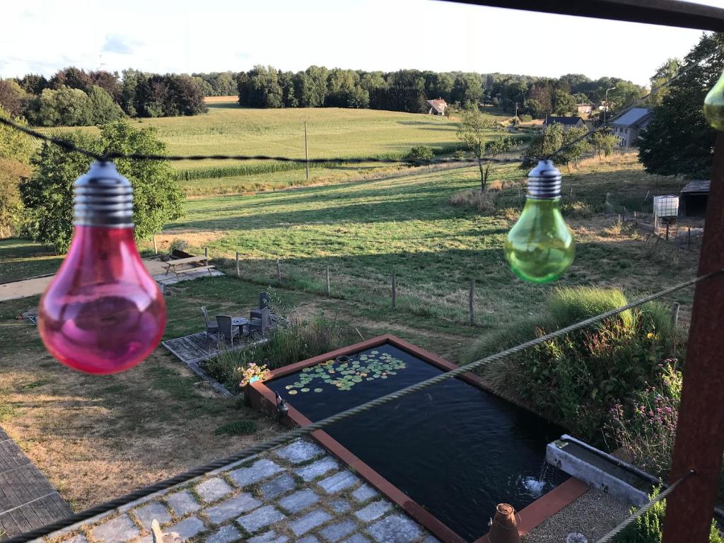 two glass bottles hanging from a fence over a pond at Le sentier des étangs in Barsy