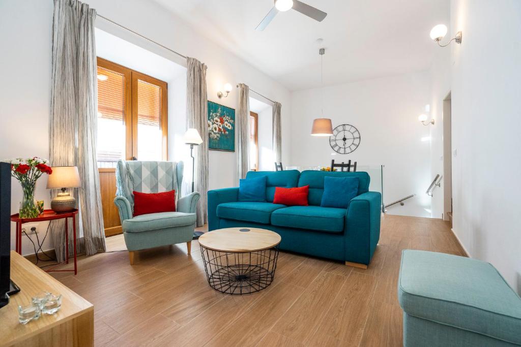 sala de estar con sofá azul y 2 sillas en Carrasco 4, en Vélez-Málaga