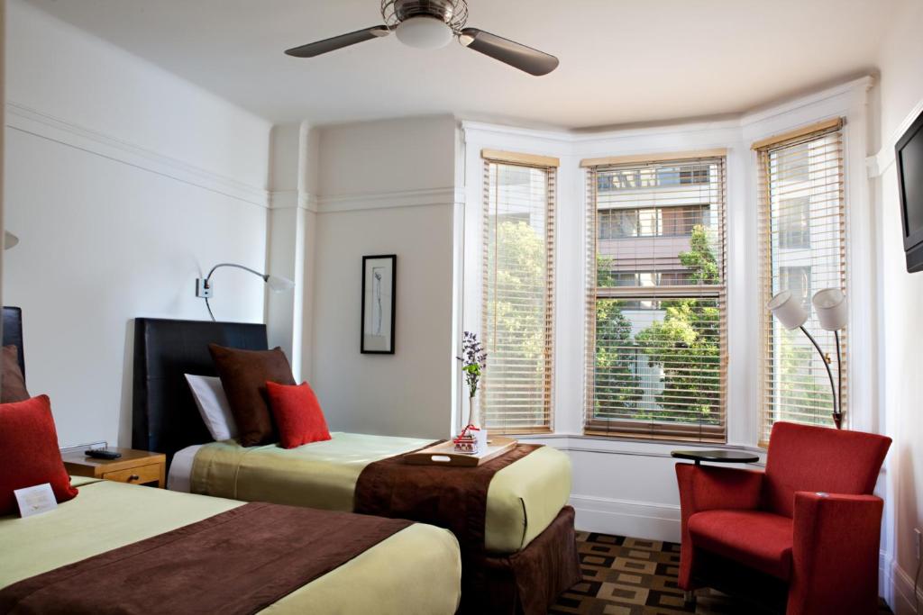 um quarto com 2 camas, uma cadeira e uma janela em The Mosser Hotel em São Francisco