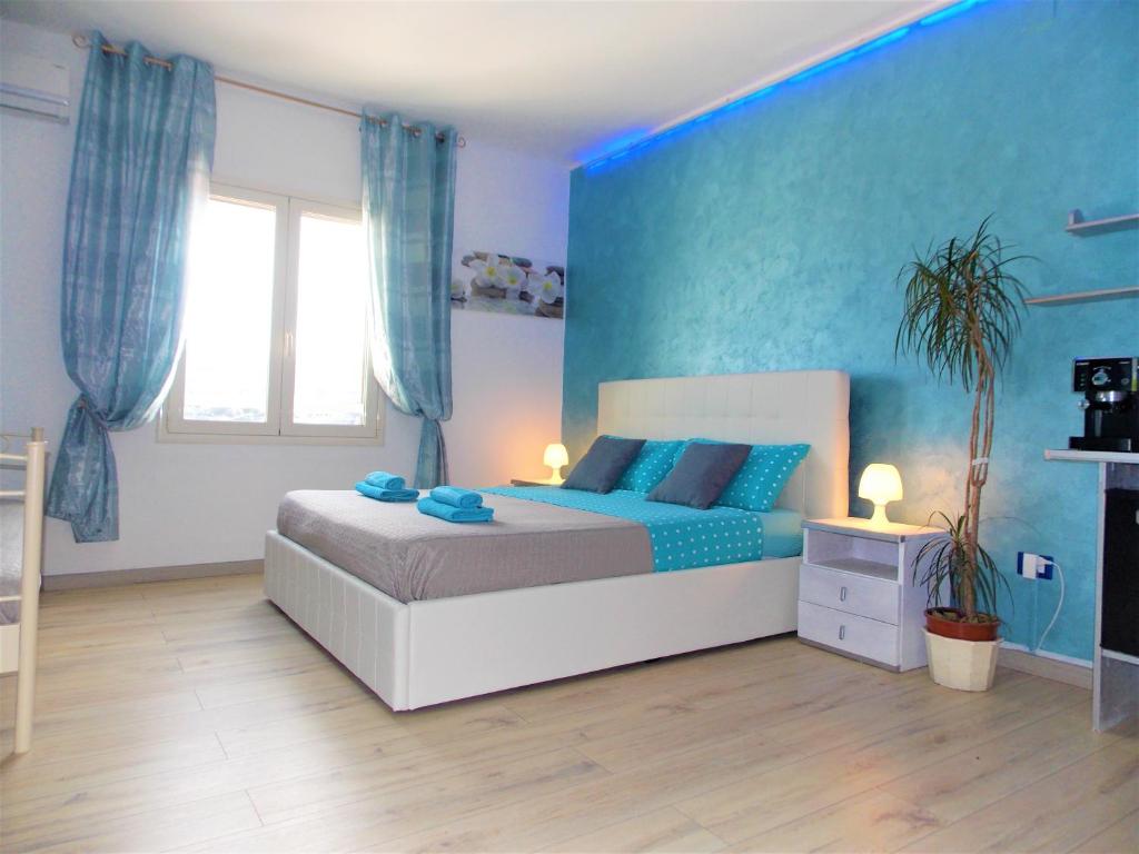 a bedroom with a bed and a blue wall at Bellagio in Castelsardo