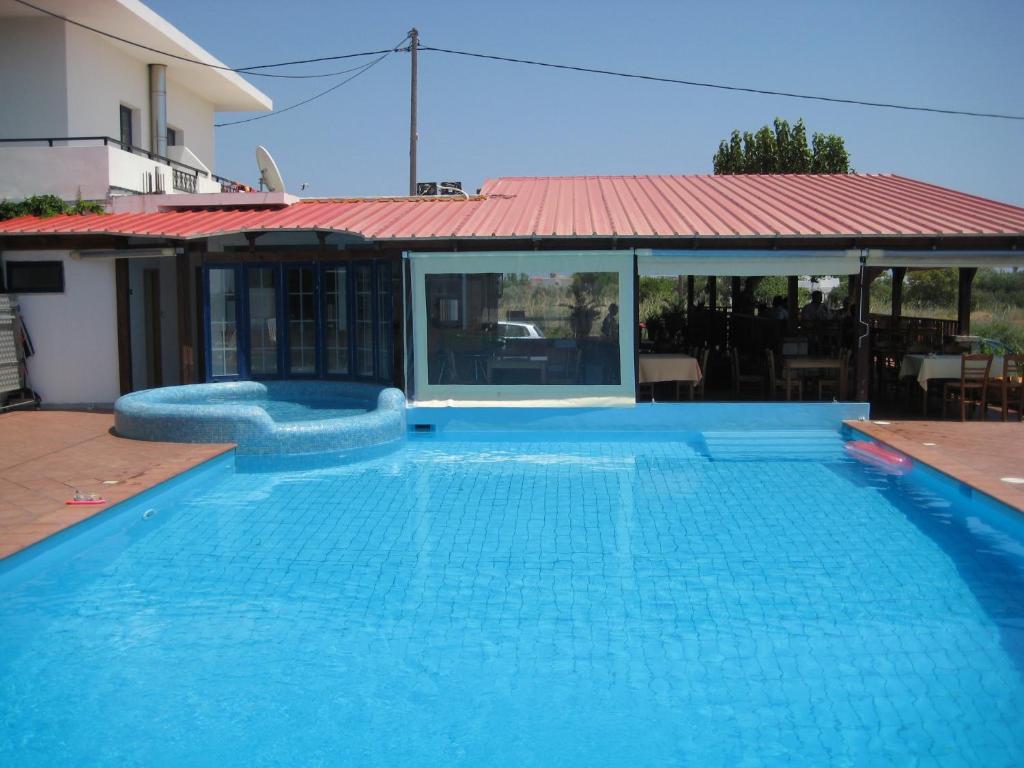 a large blue swimming pool with a red roof at Blue Sky in Frangokastello