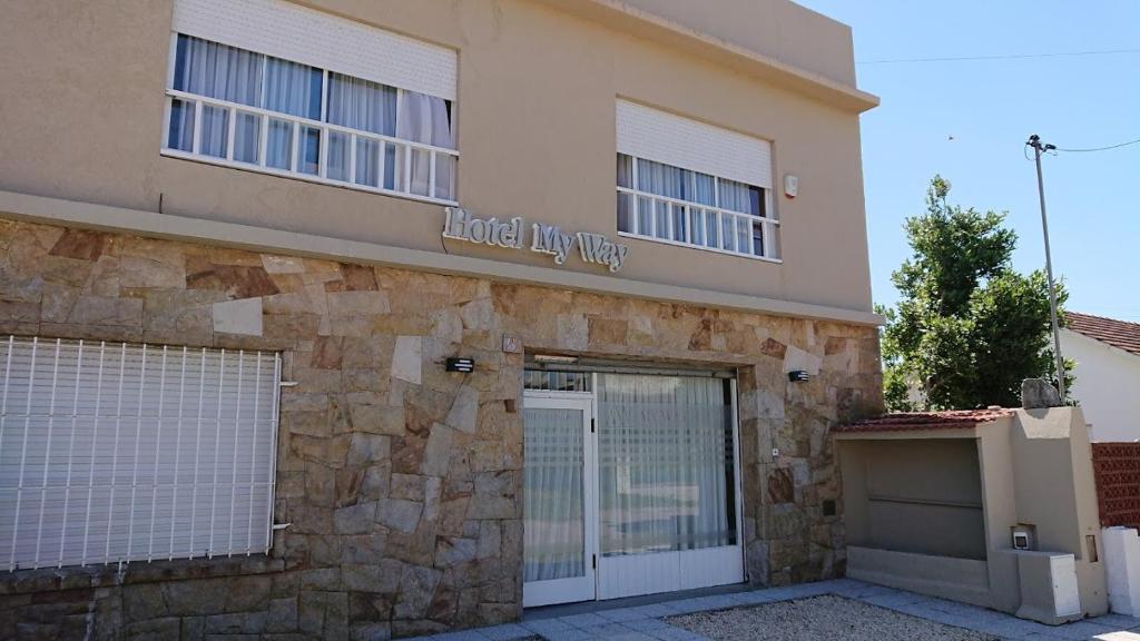 a building with two garage doors and a stone wall at Hotel My Way in Mar del Plata