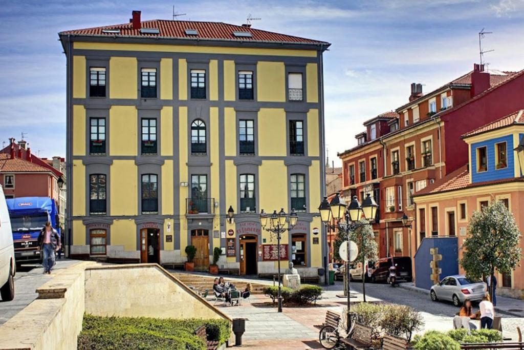 a large yellow building on a city street with buildings at ANARAL-Casco Viejo Gijon-AUTOCHECK 24h in Gijón