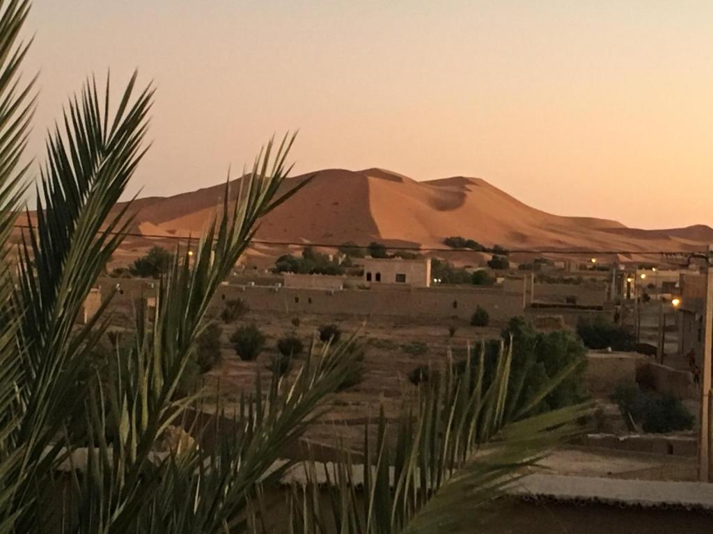 Vue sur un désert avec une montagne en arrière-plan dans l'établissement Chez Youssef, à Merzouga