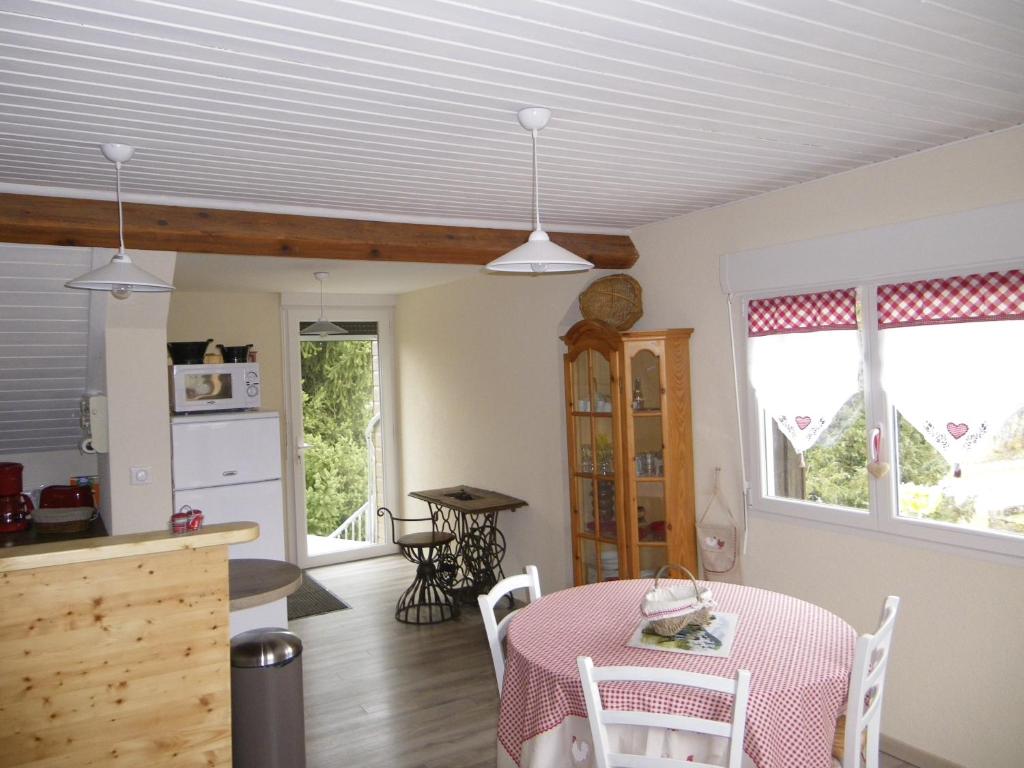 een keuken en eetkamer met een tafel en stoelen bij Gîte de campagne Dromard in Sancey-le-Long