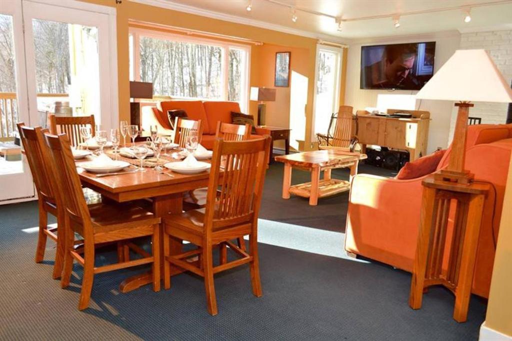 comedor con mesa de madera y sillas en Luxurious Trailside Village One Bedroom Condo #1, en Killington