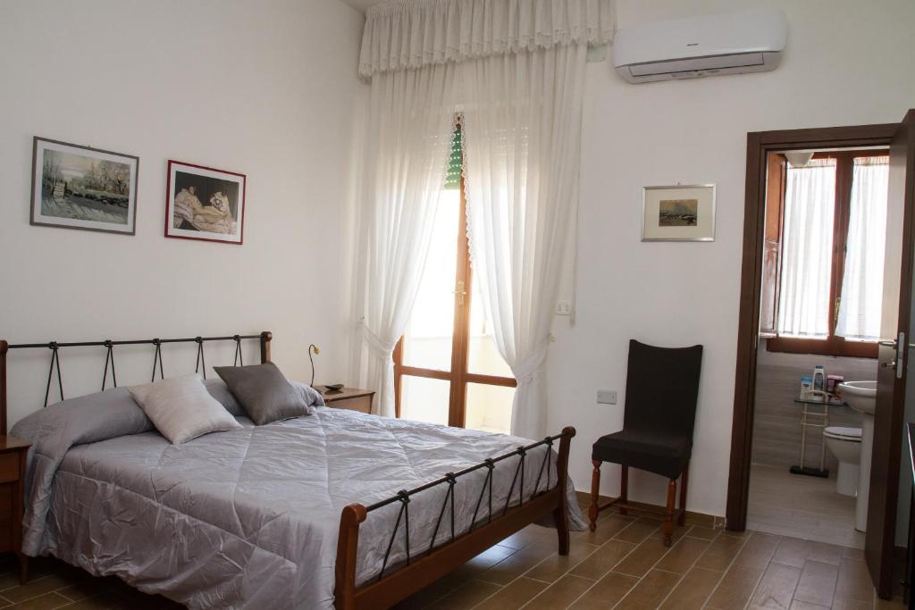 a bedroom with a bed and a chair and a window at Happy Rooms in Easy House 2 in Naples