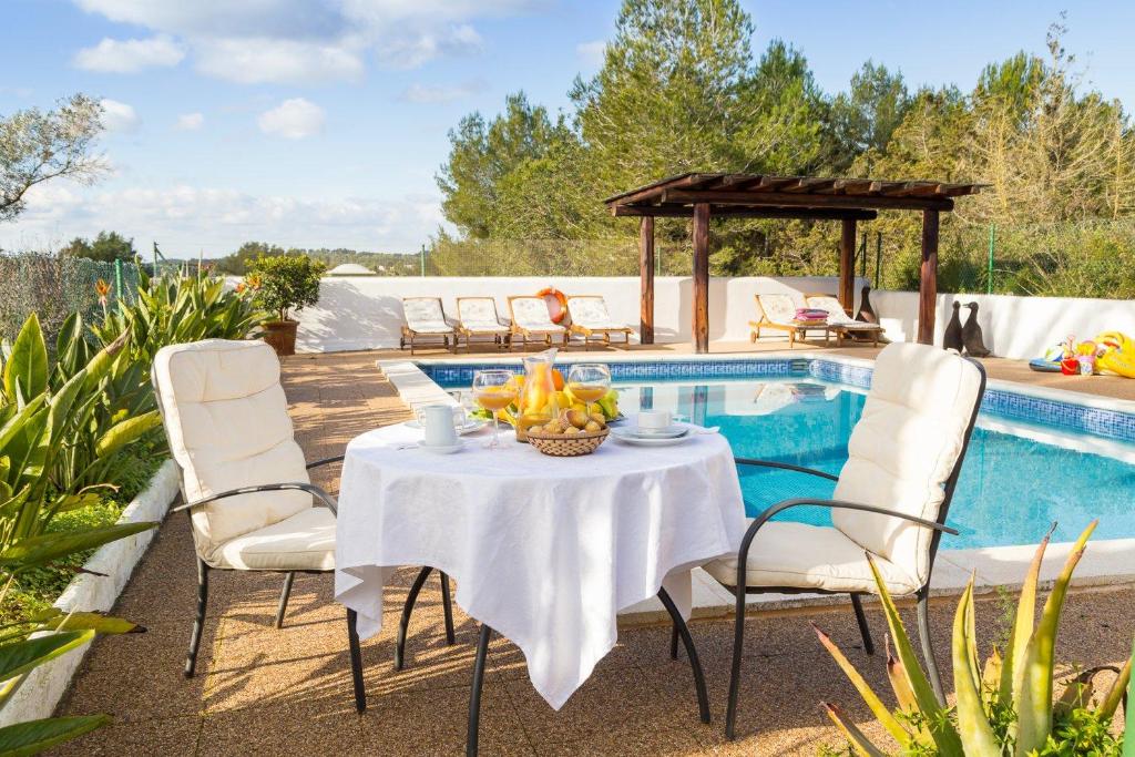 d'une terrasse avec une table et des chaises à côté de la piscine. dans l'établissement Can Agustín, à Santa Eulària des Riu