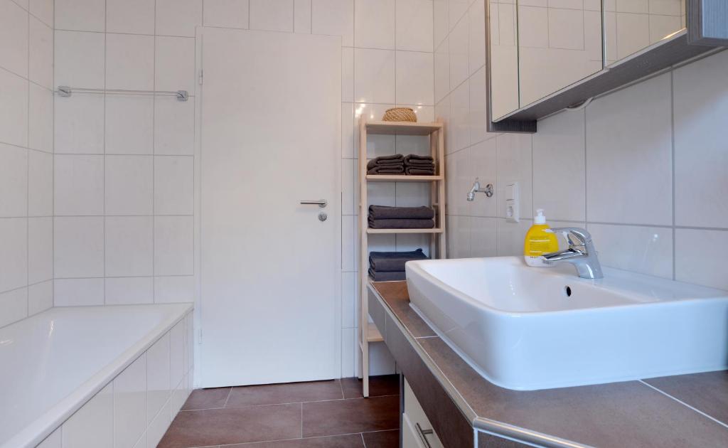 a white bathroom with a sink and a tub at Haus Daniela Superior in Cochem