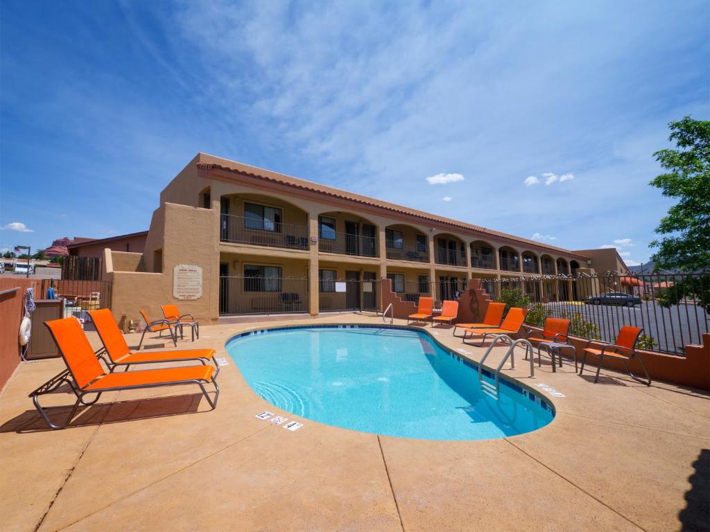 un hôtel avec une piscine, des chaises et un bâtiment dans l'établissement Desert Quail Inn Sedona at Bell Rock, à Sedona