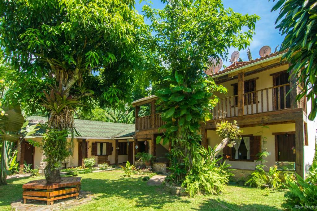 una casa vieja con árboles delante de ella en Pousada Aloes, en Paraty