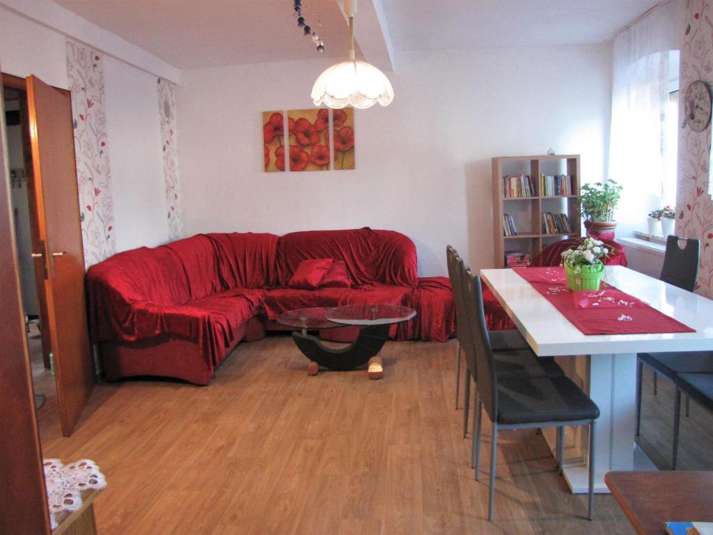 sala de estar con sofá rojo y mesa en FerienHaus Elim en Morbach