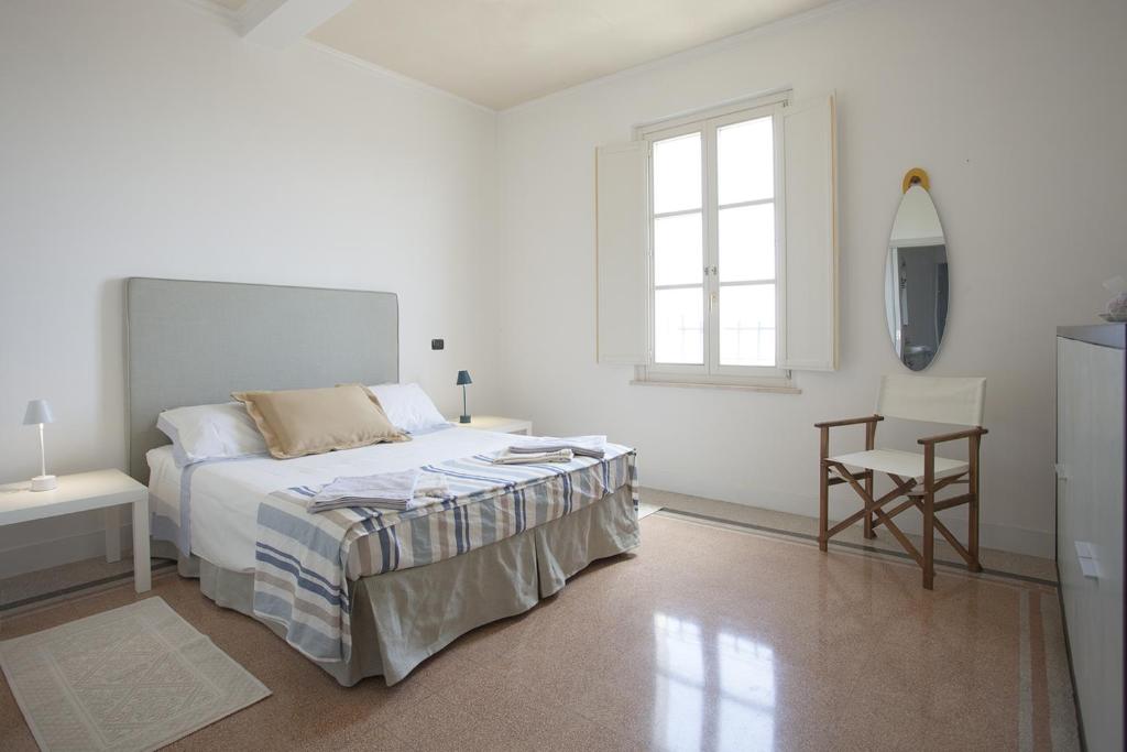 a white bedroom with a bed and a chair at Terrazza su Assisi Guest House in Perugia