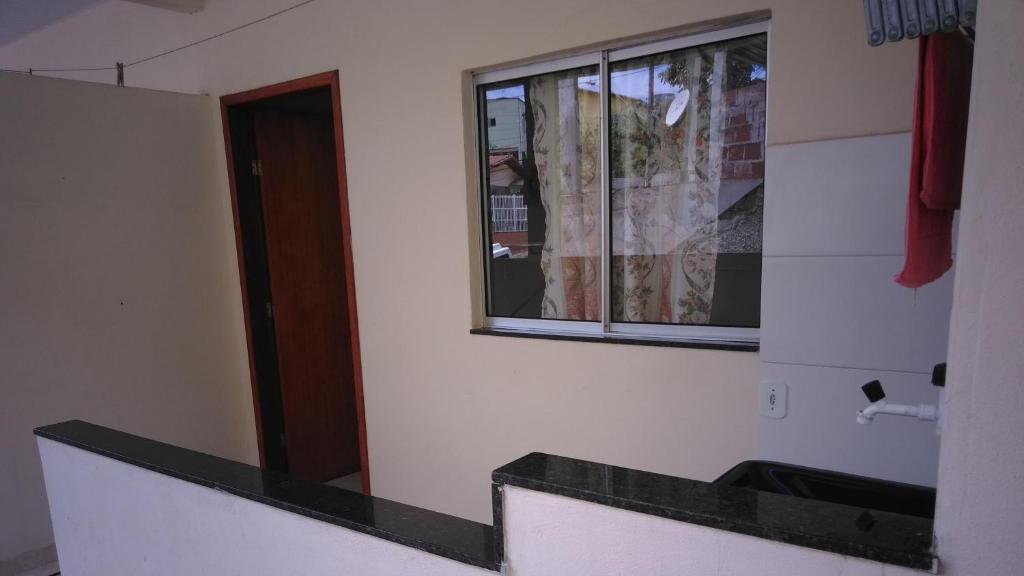a bathroom with a sink and a window at Apto Praia de Setiba 2 in Guarapari
