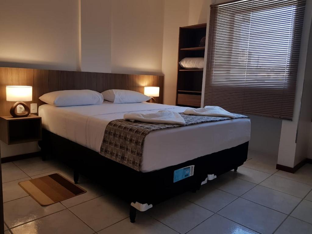a bedroom with a large bed and a window at Mamaloo Pousada in Maceió