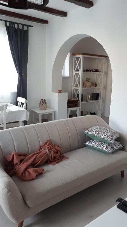 a white couch in a living room with an archway at Iarca Cottage in Bucharest