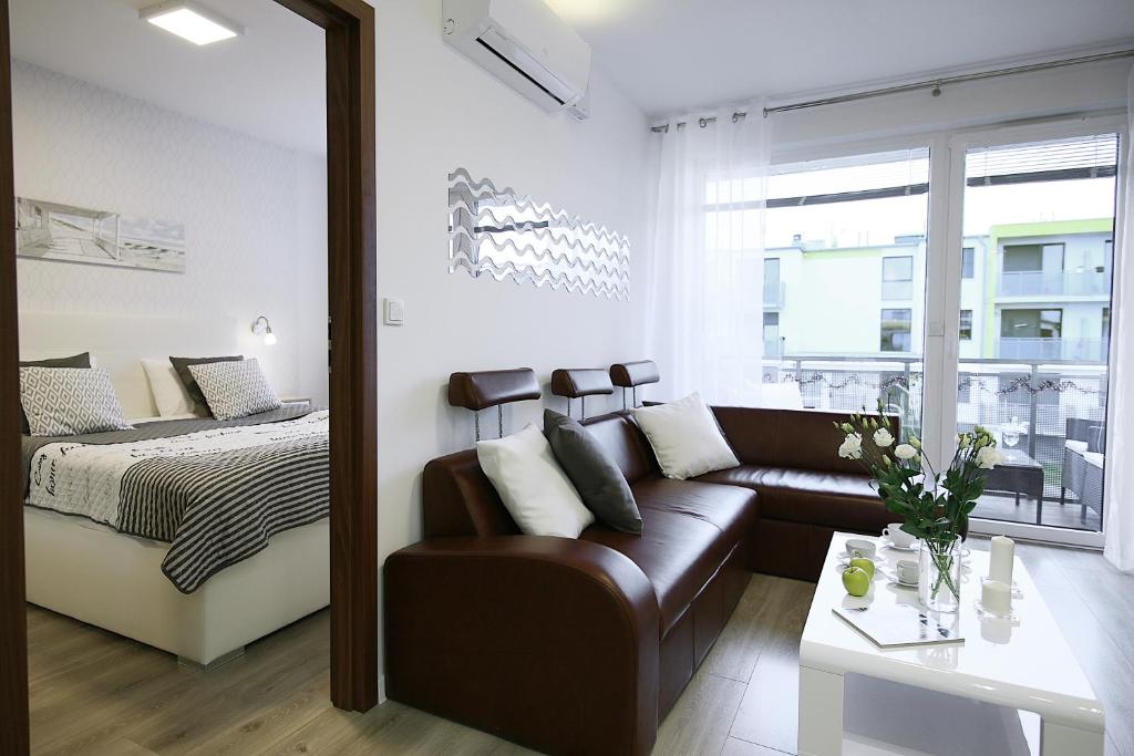 ein Wohnzimmer mit einem Sofa und einem Bett in der Unterkunft Apartimento Naturale in Breslau
